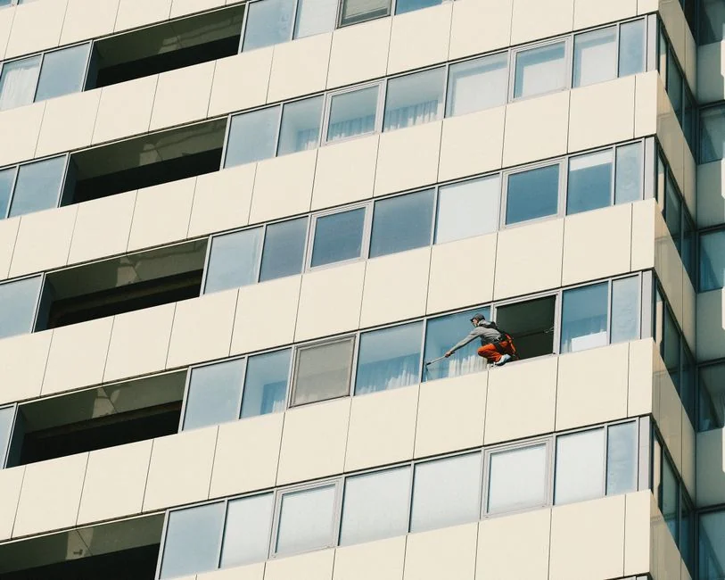 Urban worker cleaning windows on a high-rise in Ho Chi Minh City, Vietnam.